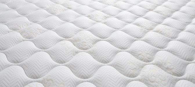 Superfície detalhada de colchão de espuma branco, mostrando textura e conforto da espuma para colchão.